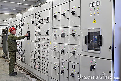 Engineer electrician switches switchgear equipment. Editorial Stock Photo