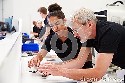 Engineer In Factory With Apprentice Checks Component Quality Stock Photo