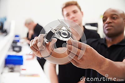 Engineer In Factory With Apprentice Checks Component Quality Stock Photo