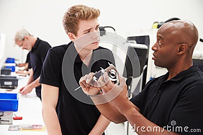 Engineer In Factory With Apprentice Checks Component Quality Stock Photo