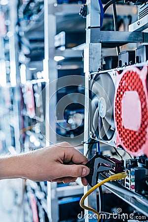 IT engineer fixing computer server on bitcoin and crypto currency mining farm Stock Photo
