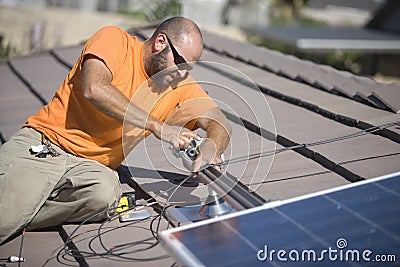 Engineer Fixing Solar Panel On Rooftop Stock Photo