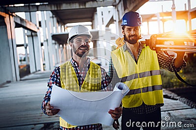 Engineer, foreman and worker discussing in building construction site Stock Photo