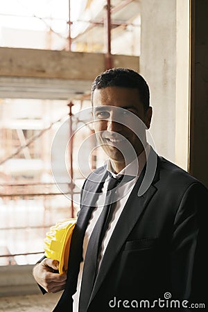 Engineer with helmet in construction site smiling at camera, portrait Stock Photo