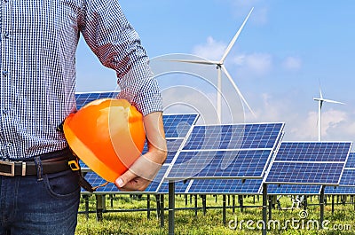 Engineer holding yellow safety helmet front solar photovoltaic and wind turbines power station Stock Photo