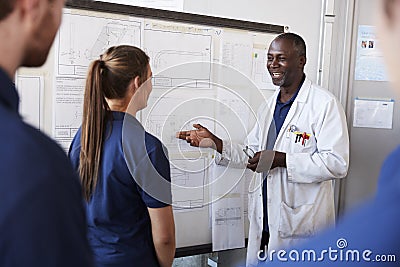 Engineer instructing apprentice at white board, close up Stock Photo