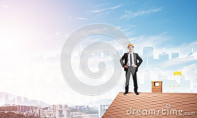 Engineer man standing on roof and looking away. Mixed media Stock Photo