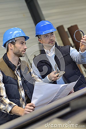 Engineer and mechanical worker discussing production Stock Photo