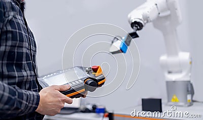 Engineer operator controls automatic mechanical arm robot to weld Stock Photo