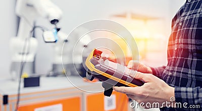 Engineer operator controls automatic mechanical robot arm to weld and collect car parts Stock Photo