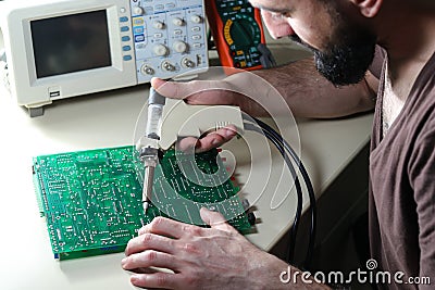 Engineer repair circuit board with Electric Vacuum Solder Sucker Stock Photo