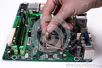Engineer repairman holding hands in black gloves chip processor, CPU to insert into the socket of the computer motherboard. The Stock Photo