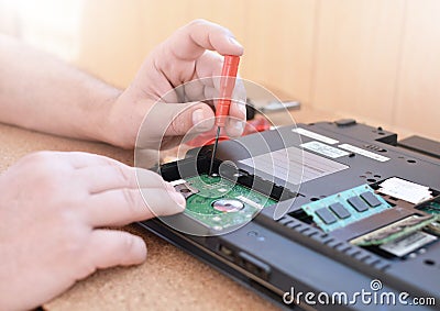 Engineer restores the laptop PC. Installing the hard drive hardware, RAM. Electronic repair shop, technology renovation Stock Photo