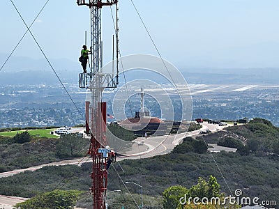 Engineer with safety equipment on high tower for working telecom communication maintenance. Editorial Stock Photo