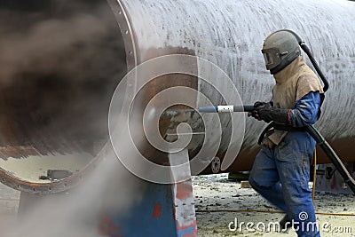 Engineer sandblasting a steel casing Stock Photo