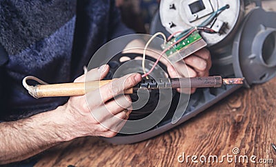 Engineer soldering circuit board of vacuum cleaner Stock Photo