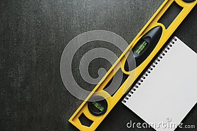 Engineer table with yellow building level and notebook Stock Photo