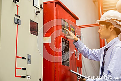 Engineer with tablet check red generator pump for water sprinkler piping and fire alarm control system. Stock Photo