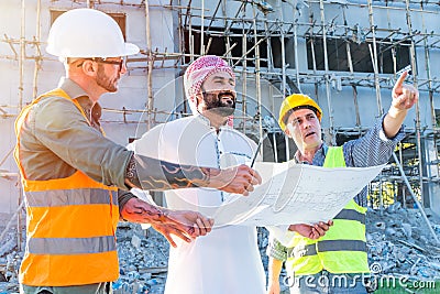 Engineer team group with Arab business estate project manager check floor plan of building at construction site Stock Photo