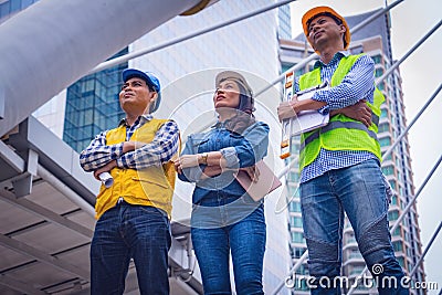 Engineer team work in town.They are embrace and see building.They are smile and gland. Stock Photo