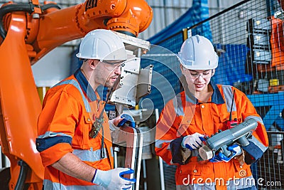 engineer team worker working program robot arm assembly machine in modern metal heavy industry factory Stock Photo