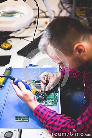 IT engineer technician repairing computer in electronics service shop Stock Photo