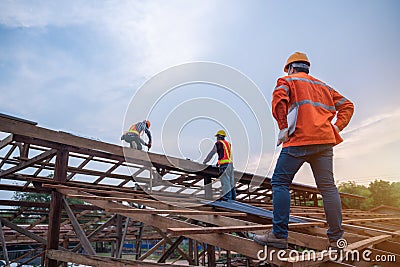 Engineer technician watching team of roofer working on roof structure of building in construction site, Roof metal sheet Stock Photo