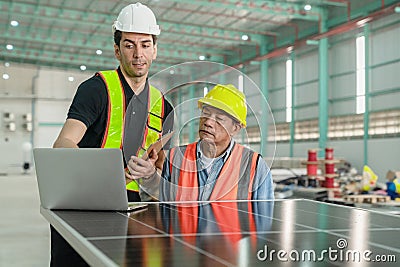 Engineer and technician working with solar panel and laptop in the factory. Stock Photo