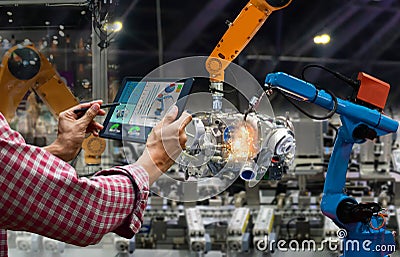 Engineer touch screen control robot the production of factory parts engine manufacturing industry Stock Photo