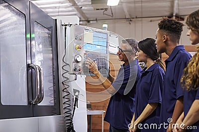 Engineer Training Apprentices On CNC Machine Stock Photo