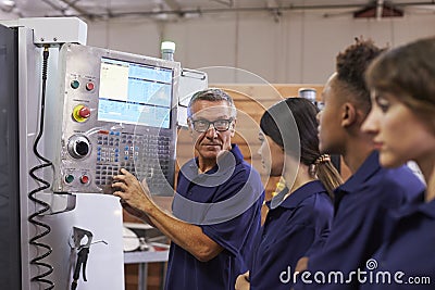 Engineer Training Apprentices On CNC Machine Stock Photo