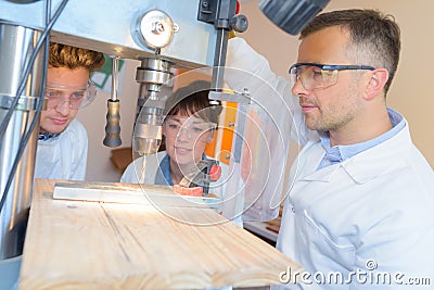 Engineer training female and male apprentice on milling machine Stock Photo