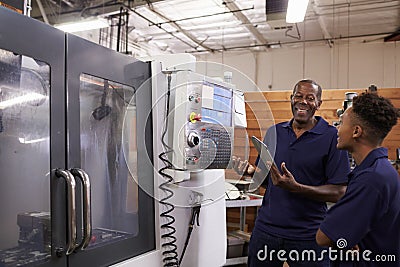 Engineer Training Young Male Apprentice On CNC Machine Stock Photo