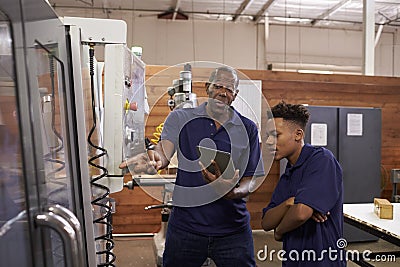 Engineer Training Young Male Apprentice On CNC Machine Stock Photo