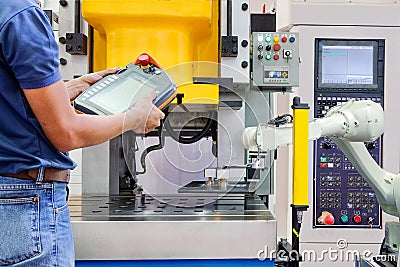 Engineer use wireless remote for control industrial robot working on smart factory Stock Photo