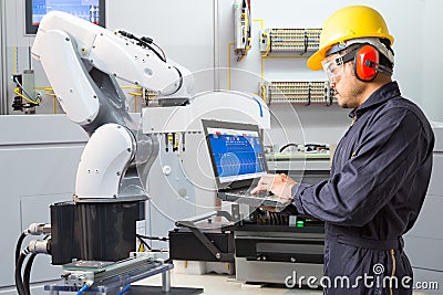 Engineer using computer for maintenance automatic robotic industry Stock Photo