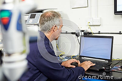 Engineer Using Computerized CMM Arm In Factory Stock Photo