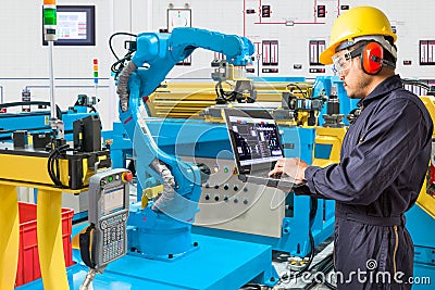 Engineer using laptop computer for control automatic robotic Stock Photo