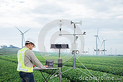 Engineer using tablet computer collect data with meteorological instrument to measure the wind speed, temperature and humidity and Stock Photo