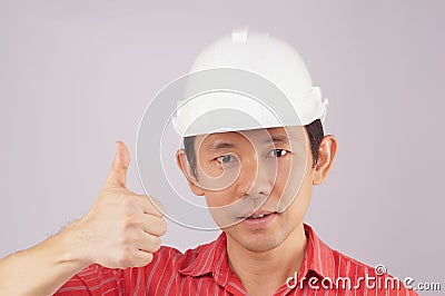 Engineer wear red shirt and white hat make signal thumb Stock Photo