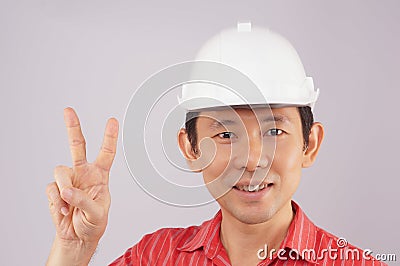 Engineer wear red shirt and white hat make signal victory Stock Photo