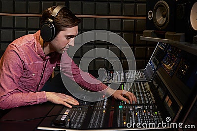 Engineer Working At Mixing Desk In Recording Studio Stock Photo