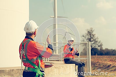 Engineer working at a wind farm for renewable energy has the responsibility of maintaining a sizable wind turbine. Encourage one Stock Photo