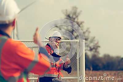 Engineer working at a wind farm for renewable energy has the responsibility of maintaining a sizable wind turbine. Encourage one Stock Photo