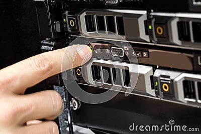 Engineer's Finger Switching On Server At Data Center Stock Photo