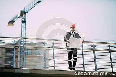 Handsome man Engineering Consulting people on construction site holding blueprint in his hand. Building inspector. Construction si Stock Photo