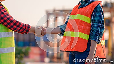 Engineering joins hand in business in industrial port background Stock Photo