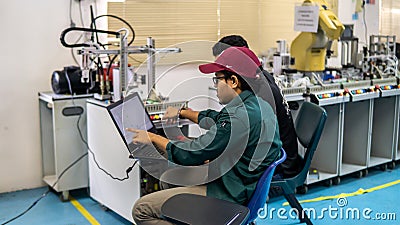 Engineering students discussing and solving the task given on the automation machine system in the laboratory Editorial Stock Photo