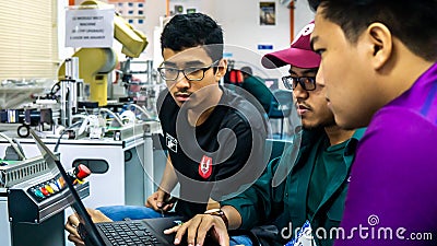 Engineering students discussing and solving the task given on the automation machine system in the laboratory Editorial Stock Photo