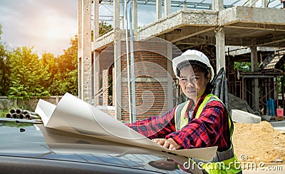 Engineers checking blueprint and planning project working outdoors building side on a worksite, Engineering and architecture Stock Photo